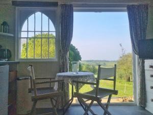 a kitchen with a table and two chairs and a window at Provender beautiful views and intimate comfort in Guestling