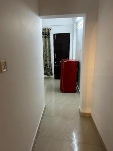 Rock View Palace Lighthouse Beach Resort في تريفاندروم: ثلاجة حمراء في الردهة مع باب +صورة واحدة