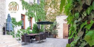 a patio with a table and chairs and an umbrella at Shato Luxe in Odesa
