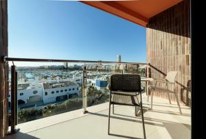 a balcony with a chair and a view of a harbor at INNSiDE by Meliá Alicante Porta Maris in Alicante