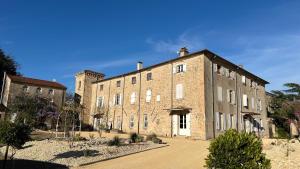 a large brick building with a blue sky in the background at Château de Lemps in Lemps