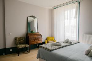a bedroom with a bed and a mirror and a chair at Château de Lemps in Lemps