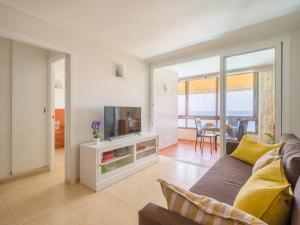 a living room with a couch and a flat screen tv at Amanecer Playa Patalavaca in Patalavaca