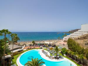 an aerial view of a resort with a swimming pool and the ocean at Amanecer Playa Patalavaca in Patalavaca