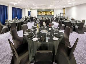 a conference room with tables and chairs with wine glasses at Mercure Cardiff North Hotel in Cardiff
