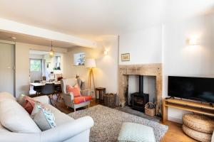 a living room with a white couch and a fireplace at Edge Cottage in Curbar