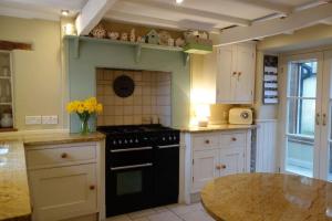 a kitchen with a black stove and a table at Peak District Luxury cottage, sleeps 8 plus pets in Tideswell