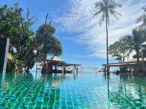 a swimming pool at a resort with palm trees at Coco Lanta Resort in Ko Lanta