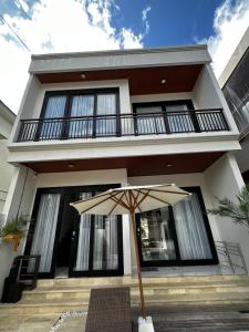 ein Haus mit einem Regenschirm davor in der Unterkunft Ramana Villa Uluwatu in Uluwatu