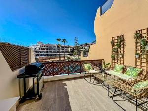 a balcony with two chairs and a grill on a building at Mandarina 326 in San Miguel de Abona