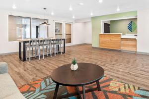 a living room with a table and a kitchen at WoodSpring Suites Indio - Coachella Valley in Indio