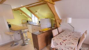 a kitchen with a table and a kitchen with a refrigerator at Gîtes Ange et Bacchus in Villecresnes