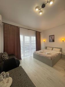 a bedroom with a large bed and a large window at Hotel Femina in Zhytomyr