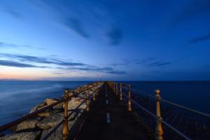 a pier stretches out into the ocean at night at Amalfi Luxury House in Amalfi