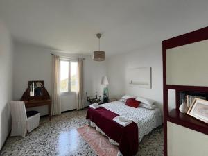 Un dormitorio con una cama y un escritorio y una ventana. en Villa Vento Largo, Casa Marina, en Ventimiglia