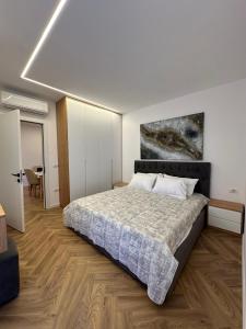 a bedroom with a bed and a painting on the wall at Brand New Apartament in Golem