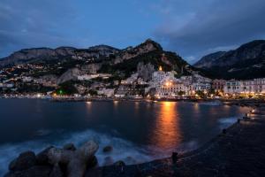 a view of a town on the water at night at Amalfi Luxury House in Amalfi
