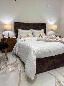 una camera da letto con un letto grande con lenzuola bianche di Ideal studio in villa 255 panafig 11 private villa in 5th settelment in New Cairo a Il Cairo