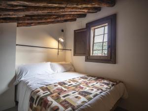 una camera da letto con un letto con una trapunta sopra di La casa amarilla apartamento calomarde ad Albarracín