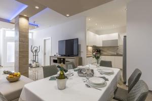 a dining room with a white table and chairs at Zvonimir Holiday with large 95m2 pool in Solin