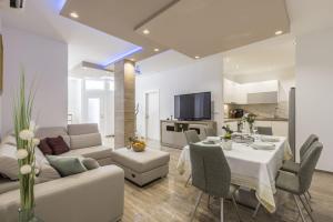 a living room with a couch and a table with chairs at Zvonimir Holiday with large 95m2 pool in Solin