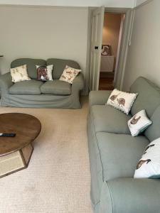 a living room with two couches and a table at The Stud House at Danebury in Stockbridge