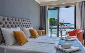 a bedroom with a bed with a view of the ocean at Hotel Koral in Medulin