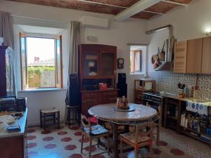 a kitchen with a table in the middle of a room at Pilarella Gallery trilocale vistamare in Porto Santo Stefano +33 photos