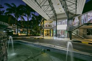 a swimming pool in a building with a fountain at Cresta Thapama Hotel in Francistown