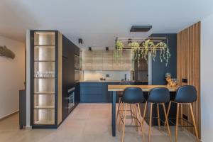 a kitchen with blue cabinets and a table with stools at Terrace, sea view, pool, parking space & fibre in Tarifa