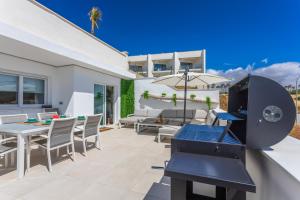 a patio with a table and chairs and a grill at Terrace, sea view, pool, parking space & fibre in Tarifa