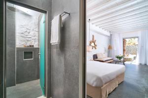 a bedroom with a bed and a shower in a room at Hippie Chic Hotel in Agios Ioannis Mykonos