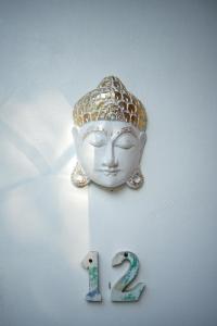 uma máscara branca na parede com o número vinte e dois em Coco Resort Penida em Nusa Penida