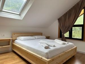 una camera da letto con un letto grande con lenzuola bianche di Ferma e bleteve Stomici a Ndërlysaj