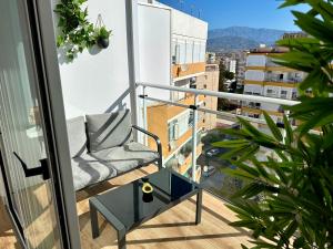 a chair on a balcony with a view of a city at Apartamento Bambú in Torre del Mar
