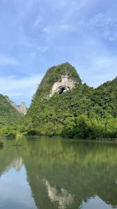a mountain in the middle of a body of water at Cao Bang Loop Homestay - Camping & Daily Trekking Tour in Thăng Hen