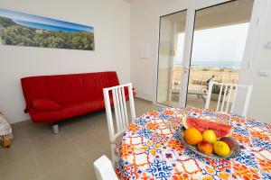 a room with a table with a bowl of fruit on it at IL GIARDINO DAMARE in Donnalucata +47 photos