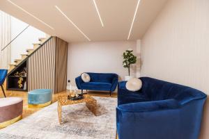 a living room with two blue chairs and a table at Kárász16 Apartman Szeged in Szeged +20 photos