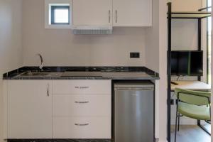 a kitchen with a sink and a microwave at HOTEL PORTOMARÍN STAR in Portomarin