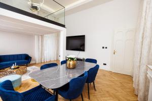 a dining room with a table and blue chairs at Kárász16 Apartman Szeged in Szeged