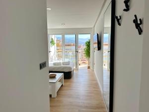 a hallway with a bed and a living room at Apartamento Bambú in Torre del Mar +5 photos
