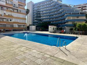 a swimming pool in front of a large building at Apartamento Bambú in Torre del Mar