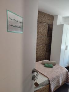 a bedroom with a bed with a sign on the door at Casa Augusta AL in Braga