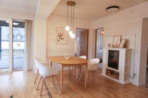 a dining room with a table and chairs and a fireplace at Hotel & Chalets by Revex in Schwarzenbach am Wald