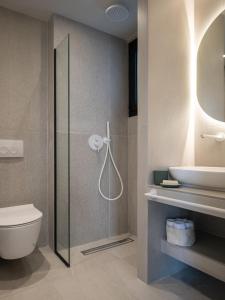 a bathroom with a shower and a toilet and a sink at Villas THALLO in Paradisos