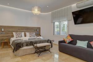 a bedroom with a bed and a couch at Villa Vista Verde Mijas Golf - Luxury with Optional heated pool & jacuzzi in Mijas +130 photos