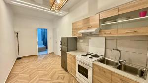 a kitchen with stainless steel appliances and wooden cabinets at Emy Studios in Fanari