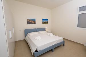 a bedroom with a bed in a white room at IL GIARDINO DAMARE in Donnalucata