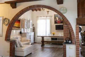 Un arco en una sala de estar con un sofá y una mesa. en Italian Experience- Podere Vallino, en Castelnuovo D'elsa