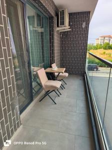 a patio with a table and chairs on a balcony at Jeni's studio in Constanţa